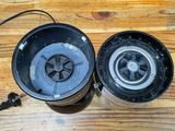 two black pots sitting on a wooden table with wires attached to them