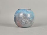 a blue and pink vase sitting on a white surface