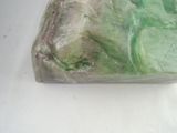 a piece of green soap sitting on a white surface