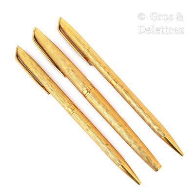 deux stylos de couleur dorée posés l'un à côté de l'autre sur une surface blanche