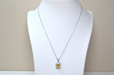 necklace with a yellow and white pendant on a white mannequin