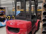 un chariot élévateur rouge garé dans un entrepôt