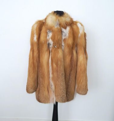 une photo d'un manteau de fourrure marron et blanc posé sur un mannequin