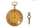 une montre de poche en or et une clé sur fond blanc