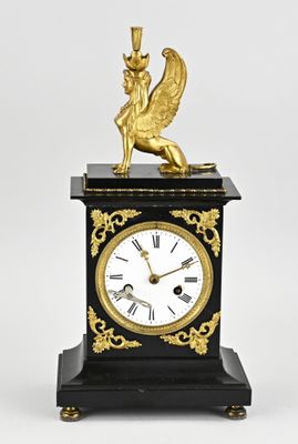 a black and gold clock with a winged figure on it