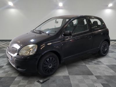la photo d'une petite voiture noire garée sur un sol en damier