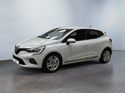 Une voiture blanche est garée dans une pièce aux murs blancs.