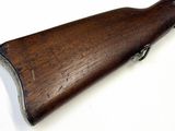 a close up of a wooden rifle on a white surface