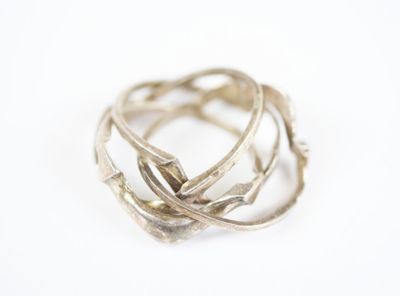 gros plan d'une bague en argent sur une surface blanche
