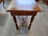 a wooden table with a drawer on it in the middle of a room