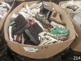 many pairs of shoes in a cardboard box on the ground