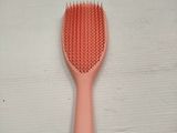 a pink hair brush on a white surface