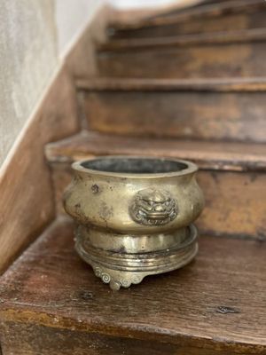 un petit bol en laiton posé sur les marches d'un escalier