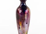 a purple vase that is sitting on a white surface