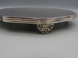 an antique silver plate with a decorative design on it