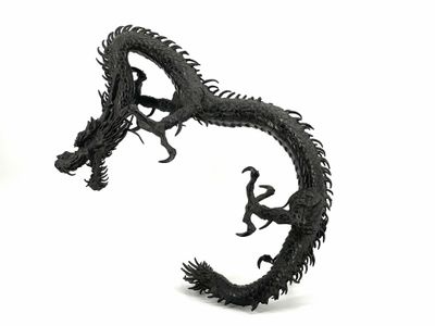 a black dragon sculpture on a white surface