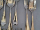 a lot of silver spoons and forks on the table