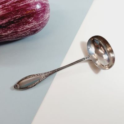 a spoon that is sitting on a table next to an eggplant