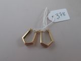 trois boucles d'oreilles géométriques dorées avec une étiquette de prix sur fond blanc