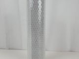 a close up of a silver vase on a white surface