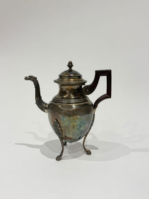 an antique teapot with a handle and a handle on a stand