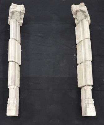 a pair of white marble columns on a black background