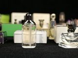 many bottles of perfume sitting on a black table