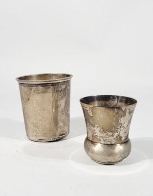 pair of silver cups on a white surface with a white background