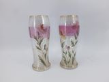 pair of vases with flowers painted on them on a white surface