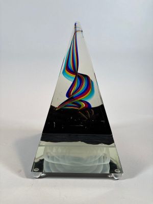 a glass sculpture of a rainbow swirl on a black base