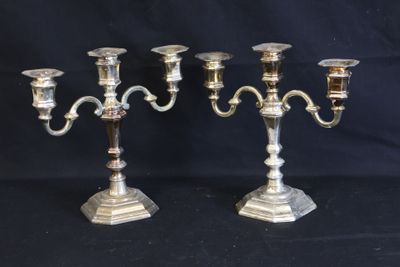 two silver candelabs on a black background with a black background