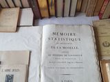 Plusieurs vieux livres sont empilés sur une table, à côté d'une pile de vieux livres
