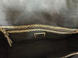 the inside of a black purse with a gold chain strap