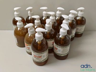 plusieurs bouteilles de liquide posées sur une table blanche