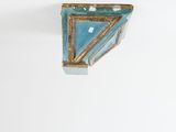 a picture of a blue and gold vase on a white wall