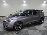 the grey car is parked on a checkered floor in a garage