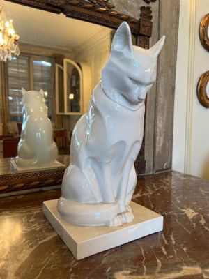 une statue représentant un chat assis sur une table en marbre