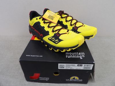 La chaussure de course jaune et noire est posée sur une boîte.