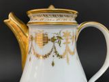 a white and gold coffee pot with a gold handle