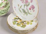 a stack of plates with flowers on them sitting on a table