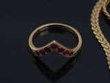 two rings and a gold chain on a black surface