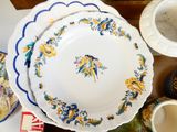 several plates and bowls are sitting on a table with a cup and saucer next to them