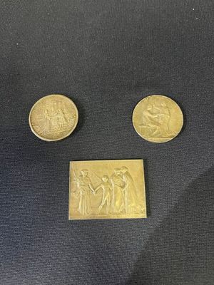 three gold coins sitting on top of a black cloth next to each other
