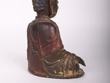 statue of a person sitting in a meditation position on a white surface