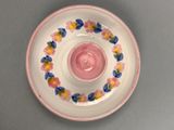 a pink plate with flowers on it sitting on a table