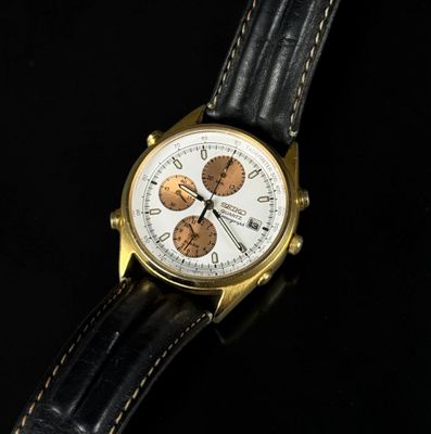 a close up of a watch on a black surface