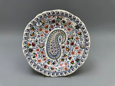 une assiette richement décorée, ornée d'un motif paisley