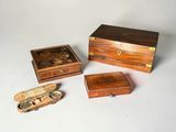 trois boîtes en bois et une petite boîte en bois posées sur une surface blanche