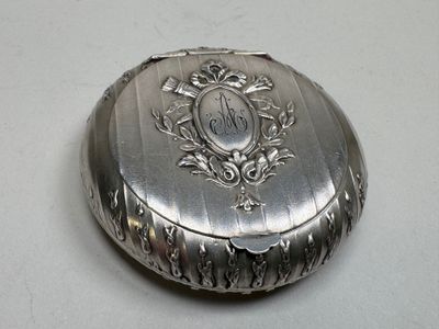 a small silver box with a monogram on it