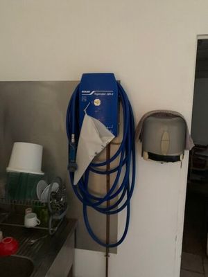 un tuyau bleu accroché au mur à côté d'un évier